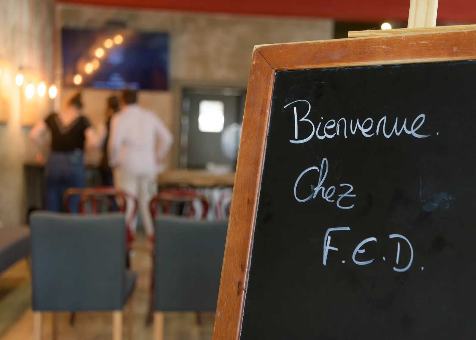 Ardoise « Bienvenue chez F.E.D. » à l'entrée de la salle, au restaurant Le Corbeau